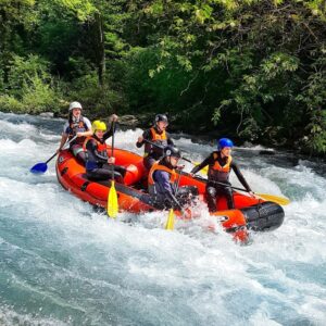 sei persone su un gommone rosso durante il rafting in Toscana
