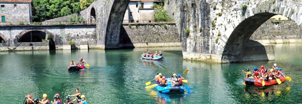 Persone in gommone fanno rafting sotto il Ponte del Diavolo sul fiume Lima in Garfagnana