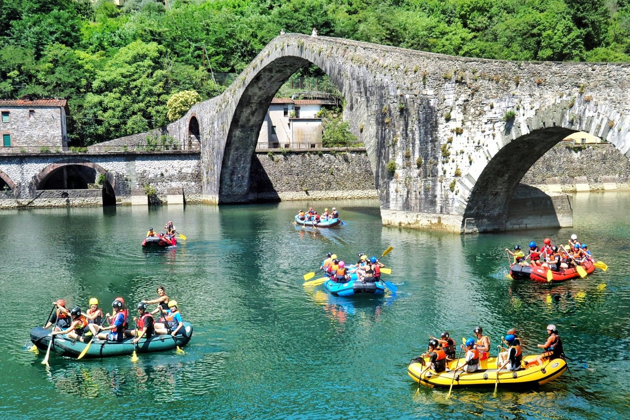 Persone in gommone fanno rafting sotto il Ponte del Diavolo sul fiume Lima in Garfagnana